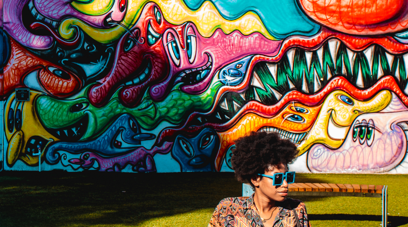 woman sitting in front of wynwood walls mural